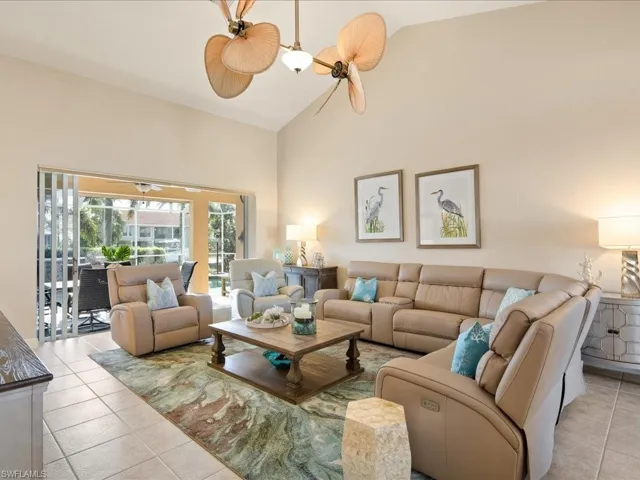 Living room featuring ceiling fan, high vaulted ceiling, and light tile patterned flooring