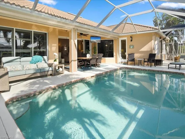 View of swimming pool with ceiling fan, a lanai, outdoor lounge area, and a patio
