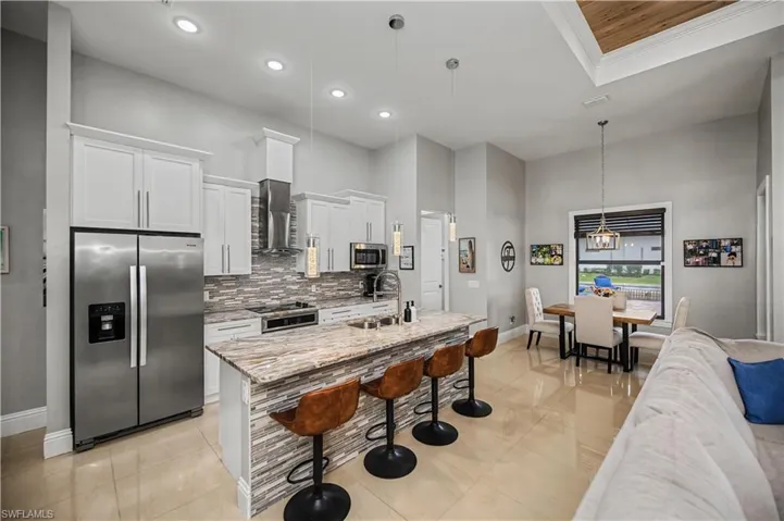 Kitchen with stainless steel appliances,  granite countertops, soft close drawers and cabinets and a massive breakfast bar with decorative lighting