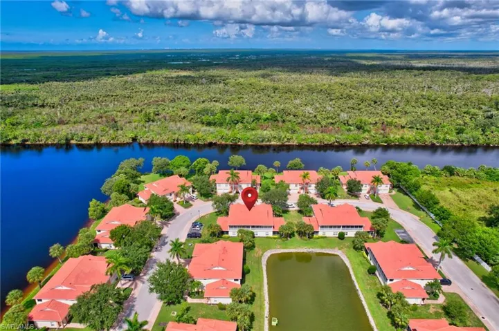 Aerial view of residential area with a heavily wooded area and a large body of water