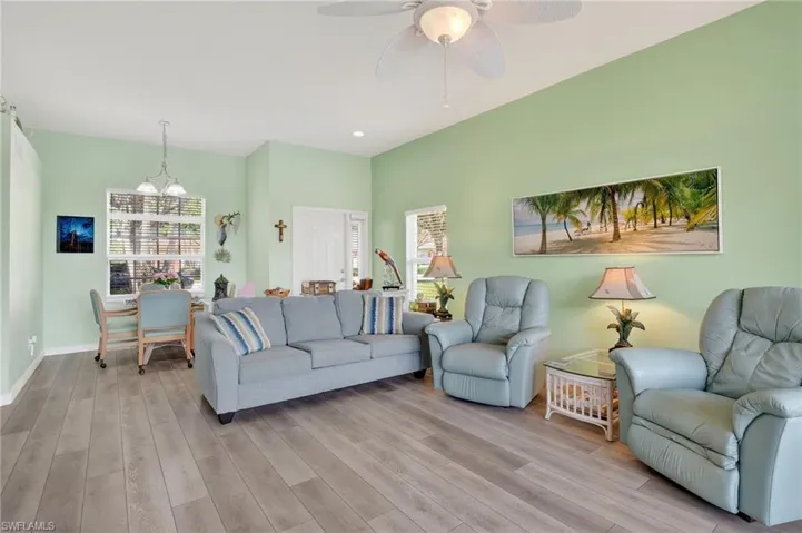 Living area with light wood finished floors, a chandelier, a ceiling fan, and recessed lighting