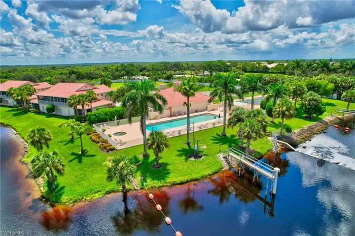 Drone / aerial view of a nearby body of water and a pool