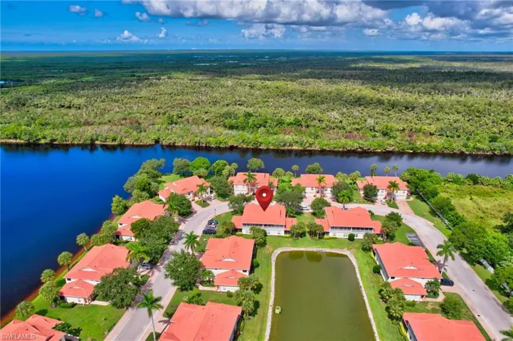 Aerial view of residential area with a large body of water and a heavily wooded area