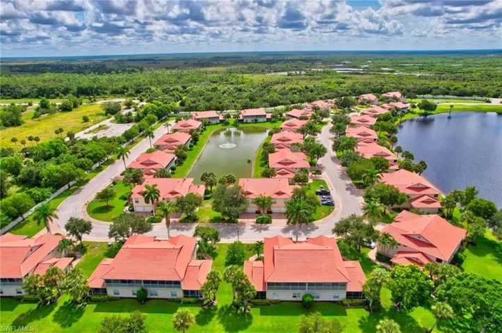 Aerial view of residential area with a large body of water and a forest
