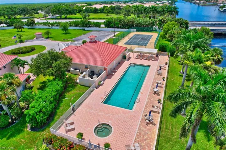Drone / aerial view of a nearby body of water and a pool