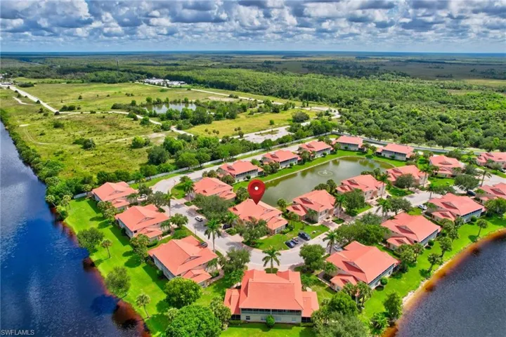 Aerial perspective of suburban area with a large body of water and a forest