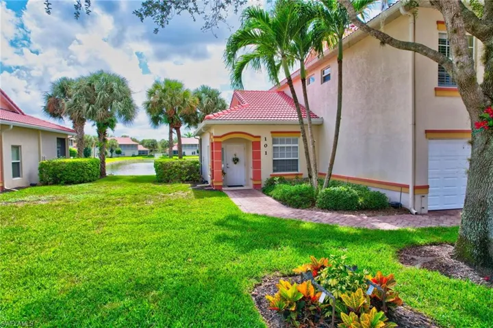 View of front of home with stucco siding, a front lawn, and a tiled roof