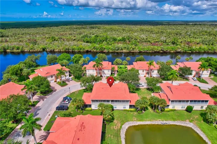 Aerial view of residential area featuring a large body of water and a forest