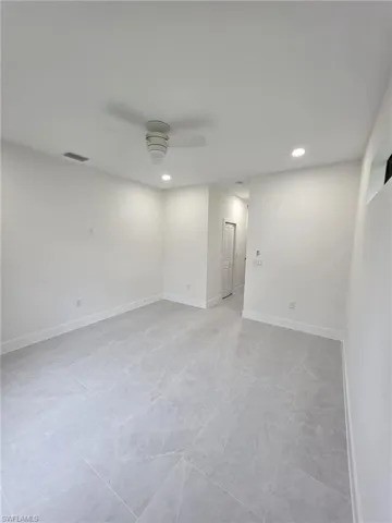 Spare room featuring a ceiling fan, recessed lighting, visible vents, and baseboards