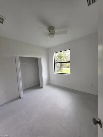Unfurnished bedroom with baseboards, visible vents, ceiling fan, and a closet