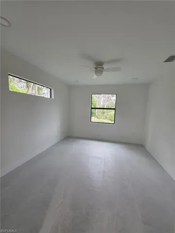 Spare room with ceiling fan, visible vents, and baseboards