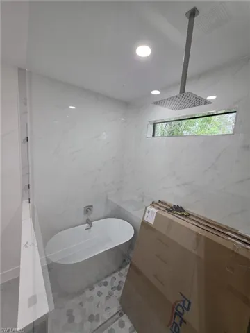 Bathroom featuring visible vents, tiled shower, a freestanding tub, tile walls, and recessed lighting