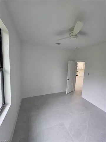 Unfurnished room with ceiling fan, visible vents, and baseboards