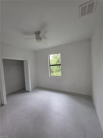 Unfurnished bedroom with baseboards, a closet, visible vents, and a ceiling fan