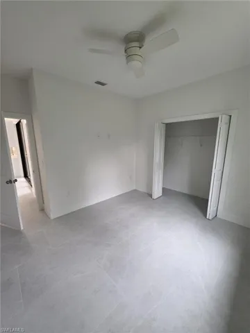 Unfurnished bedroom featuring ceiling fan, a closet, visible vents, and baseboards