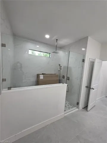 Full bath featuring a marble finish shower