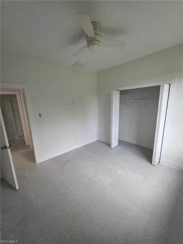 Unfurnished bedroom with ceiling fan, baseboards, and a closet
