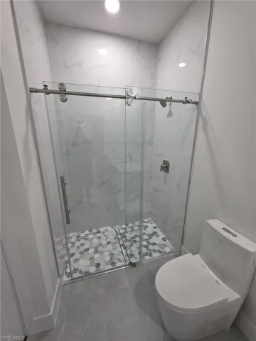 Bathroom featuring a shower stall and toilet