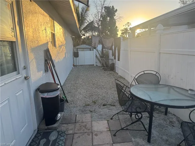 Patio terrace at dusk featuring a patio, a fenced backyard, a storage shed, and outdoor dining area