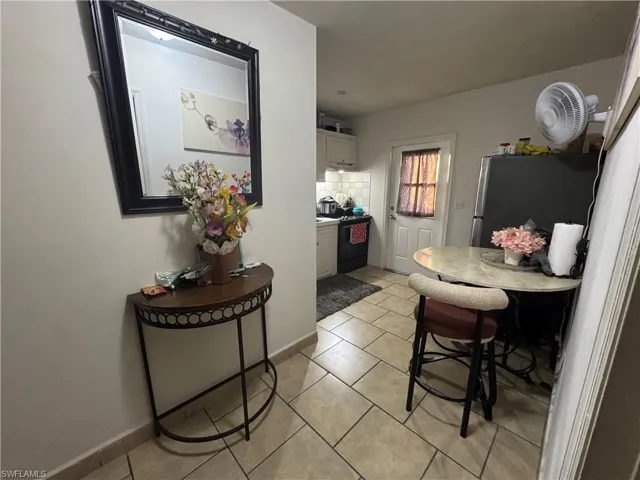 Dining space with light tile patterned flooring and baseboards