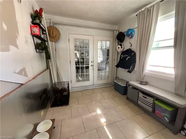 Mudroom with french doors and light tile patterned flooring