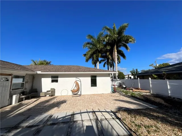 Back of house featuring stucco siding, a patio area, a fenced backyard, and a shingled roof