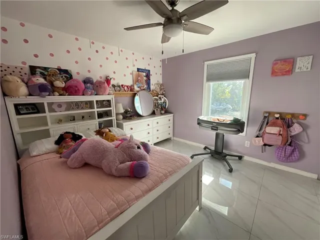 Bedroom featuring ceiling fan, light marble finish floors, and wallpapered walls