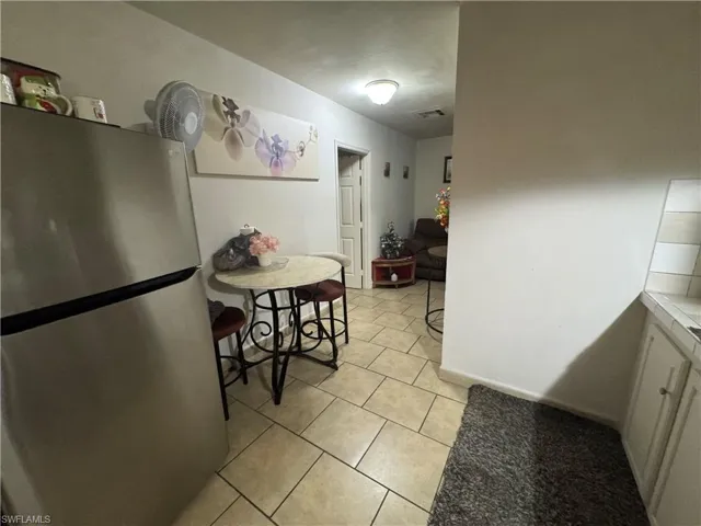 Kitchen with freestanding refrigerator, light tile patterned flooring, and tile countertops