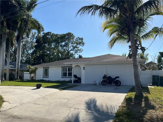 Single story home featuring roof with shingles, driveway, and stucco siding