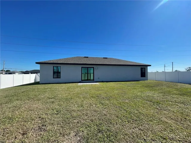 Back of property featuring a yard