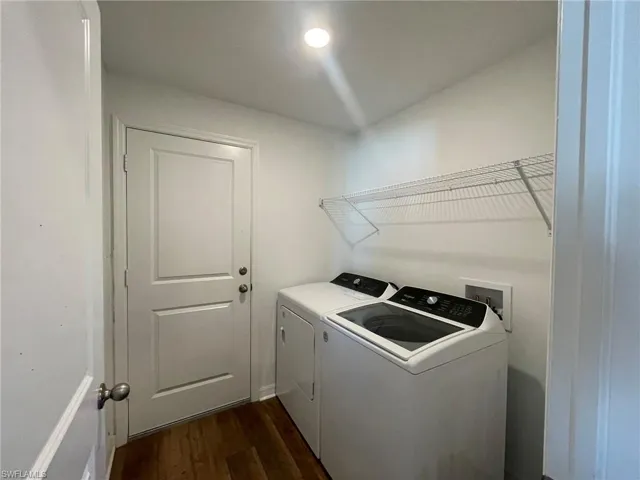 Laundry room featuring washing machine and dryer and dark hardwood / wood-style floors