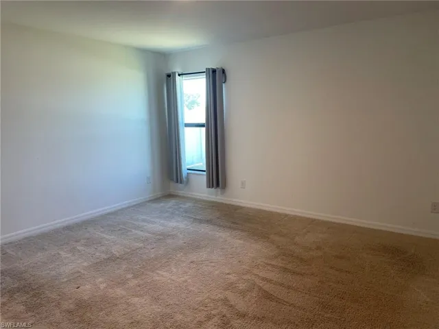 Spare room featuring light colored carpet