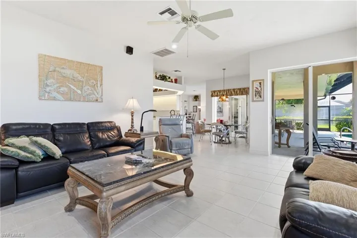 Living area with a ceiling fan and light tile patterned floors