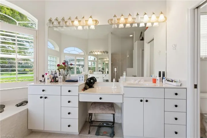 Primary Bathroom with makeup vanity and a relaxing tiled tub