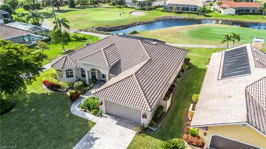 Aerial view of residential area with a nearby body of water and a local golf course