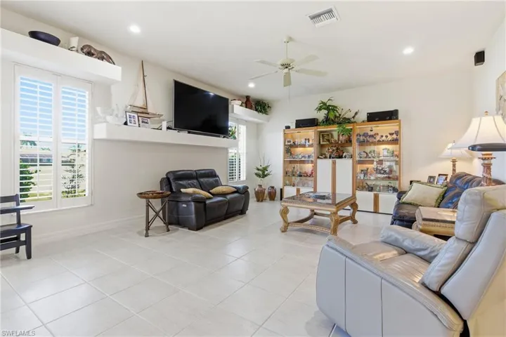 family room featuring ceiling fan and light tile patterned floors