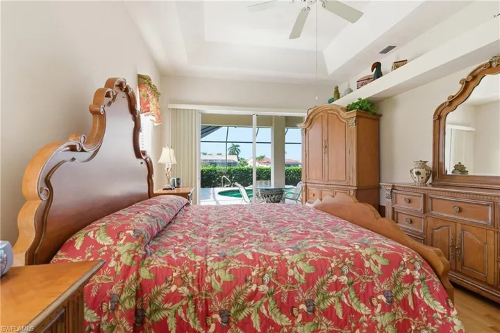 Bedroom featuring access to exterior, a tray ceiling, and ceiling fan