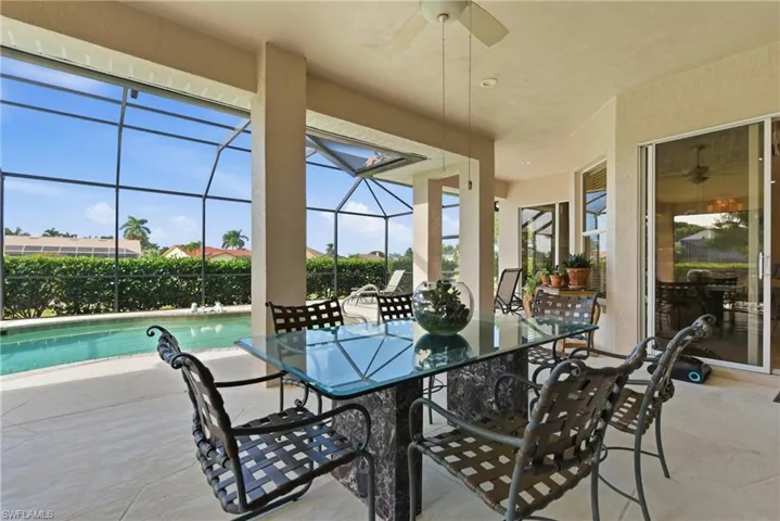 View of patio with ceiling fan, glass enclosure, and a sunroom