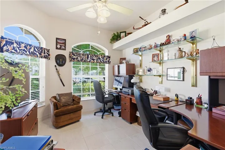Office space featuring light tile patterned floors, ceiling fan, and healthy amount of natural light