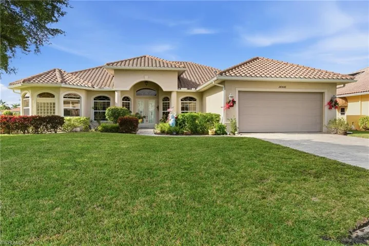 Well maintained Mediterranean / Spanish-style home with stucco siding, a front lawn, decorative driveway, and a tiled roof