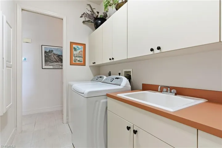 laundry room has plenty of cabinets and countertops.