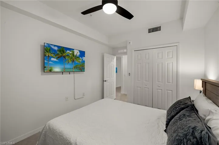 Bedroom featuring ceiling fan, tile patterned floors, and a closet