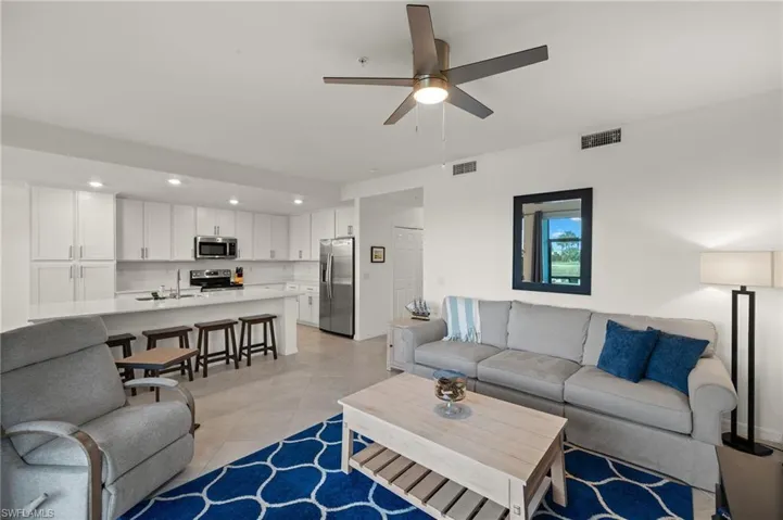 Living room featuring sink, light tile patterned floors, and ceiling fan