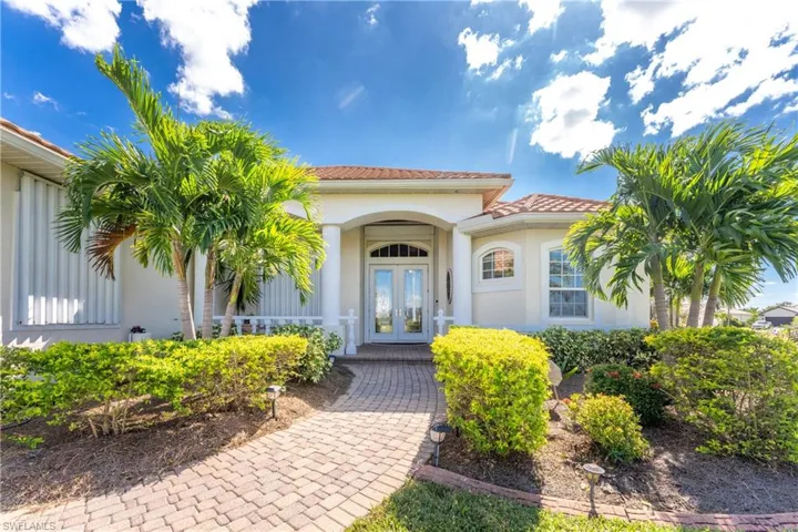 Entrance to property featuring french doors, a tile roof, and stucco siding