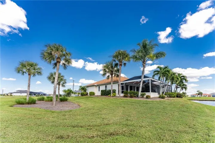 View of grassy yard featuring a lanai, a sunroom, and a water view