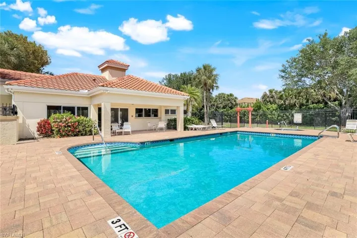 Community pool featuring a patio and fence