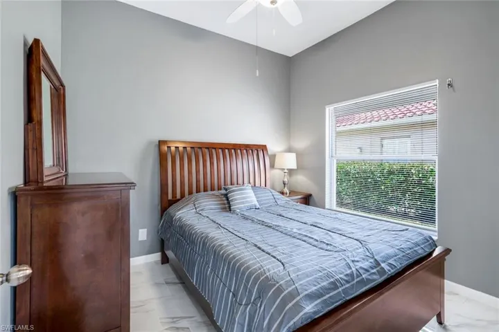 Bedroom featuring baseboards, a ceiling fan, and marble finish floor