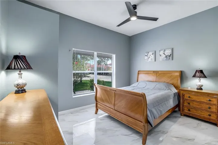 Bedroom featuring marble finish floor and a ceiling fan