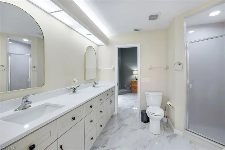 Full bathroom featuring visible vents, a sink, marble finish floor, and a stall shower
