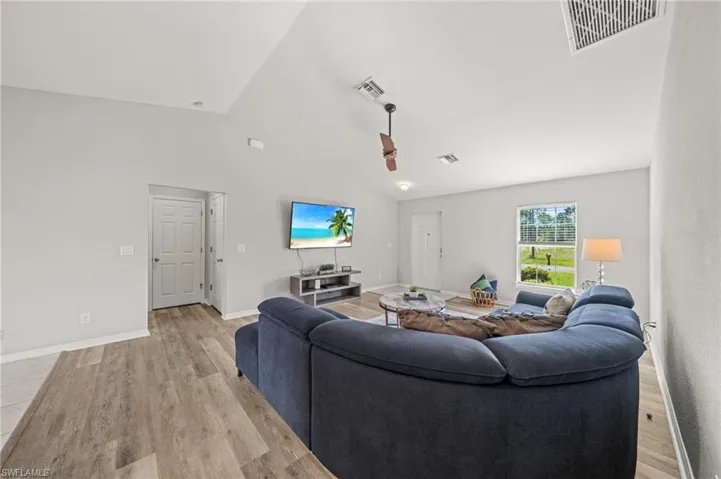 Living area featuring vaulted ceiling and light wood-style flooring